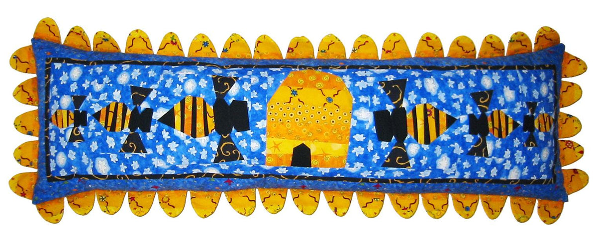 Decorative pillow with bees and a sun on a blue background.