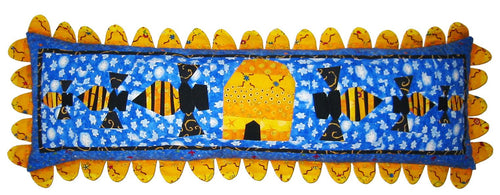 Decorative pillow with bees and a sun on a blue background.