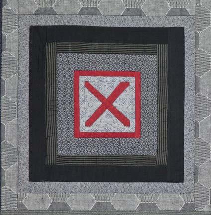 Quilt with a red 'X' design on a gray background