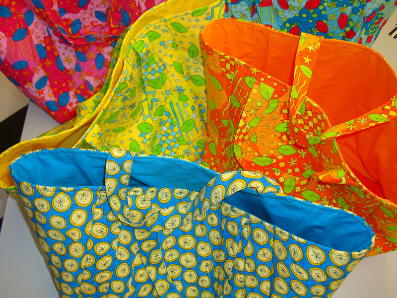 Colorful fabric bags with various patterns on a white surface