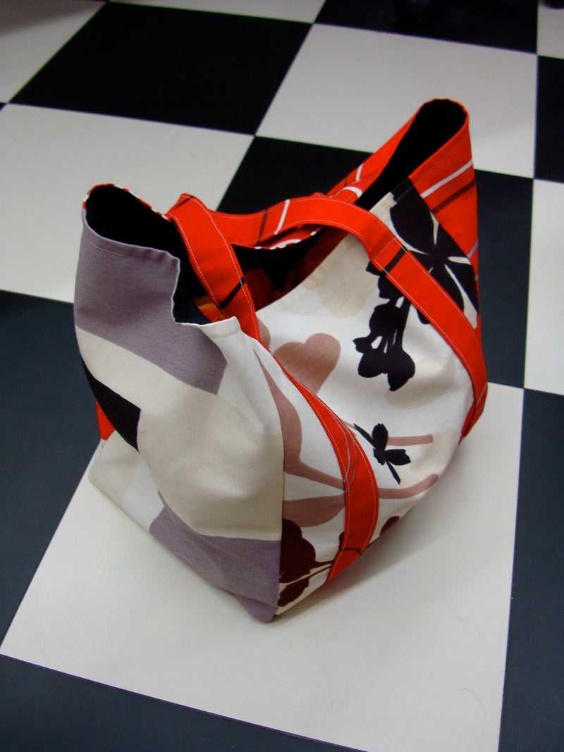 Fabric bag with abstract flower pattern and red handles