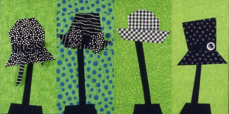 Four black and white polka dot hats on a green background with blue polka dots.
