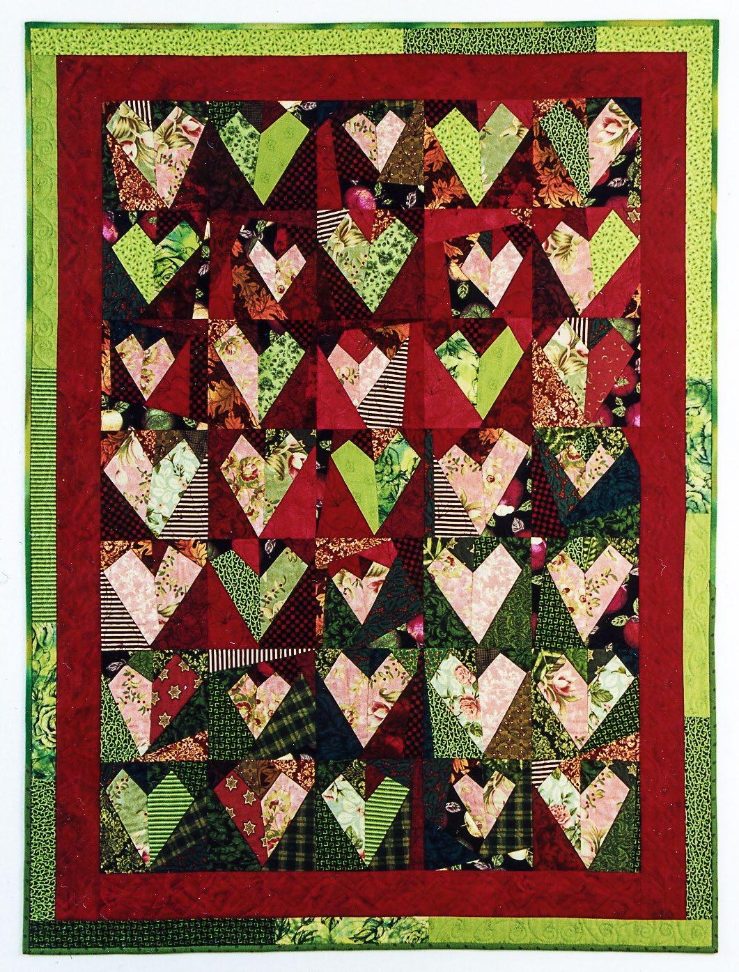 Quilt with heart patterns in red, green, and multicolor on a green border