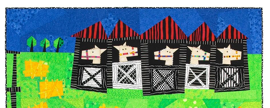 Colorful quilt of barns with red roofs on a blue and green background
