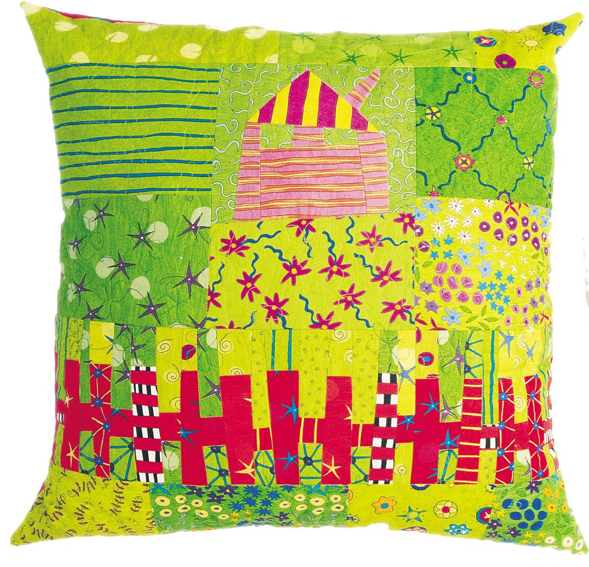Colorful patchwork pillow with a house and picket fence pattern on a white background