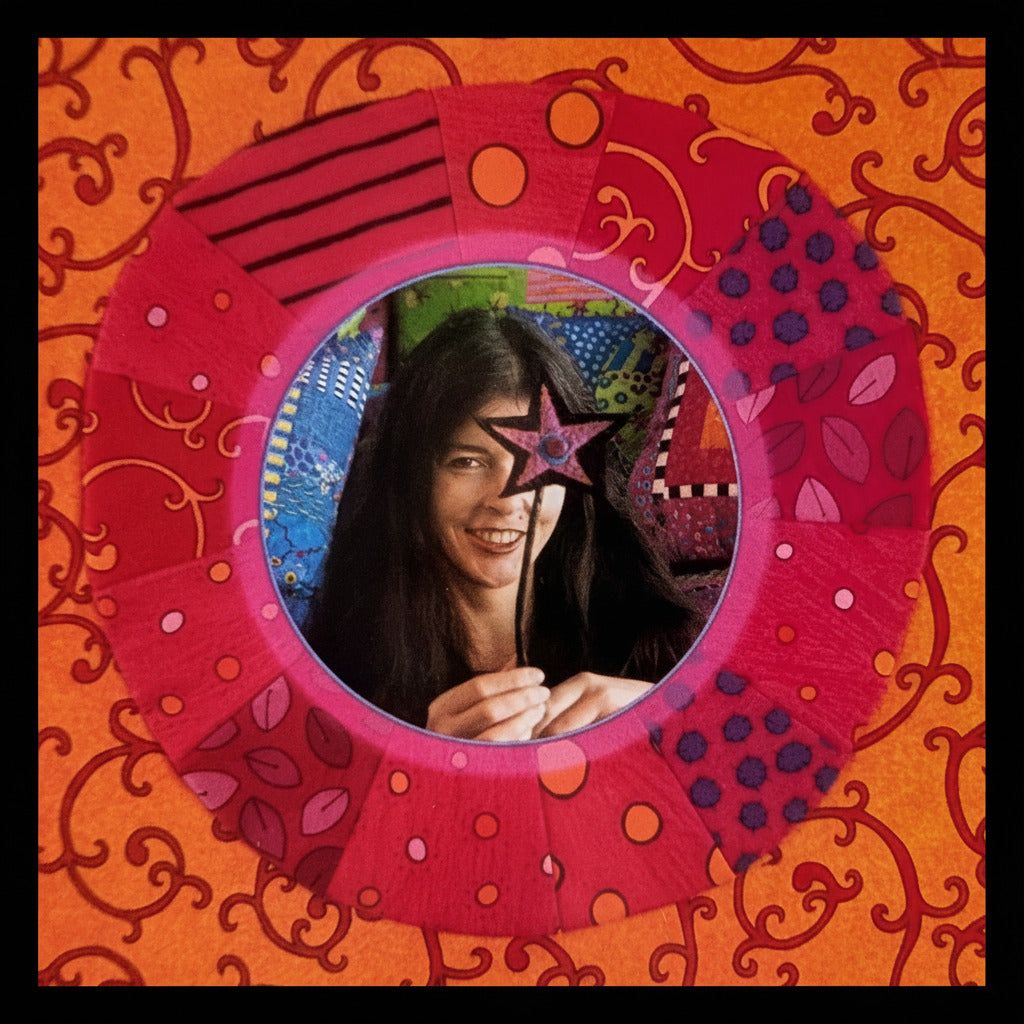 Jan Mullen holding a colorful star-shaped mirror with a vibrant, patterned background