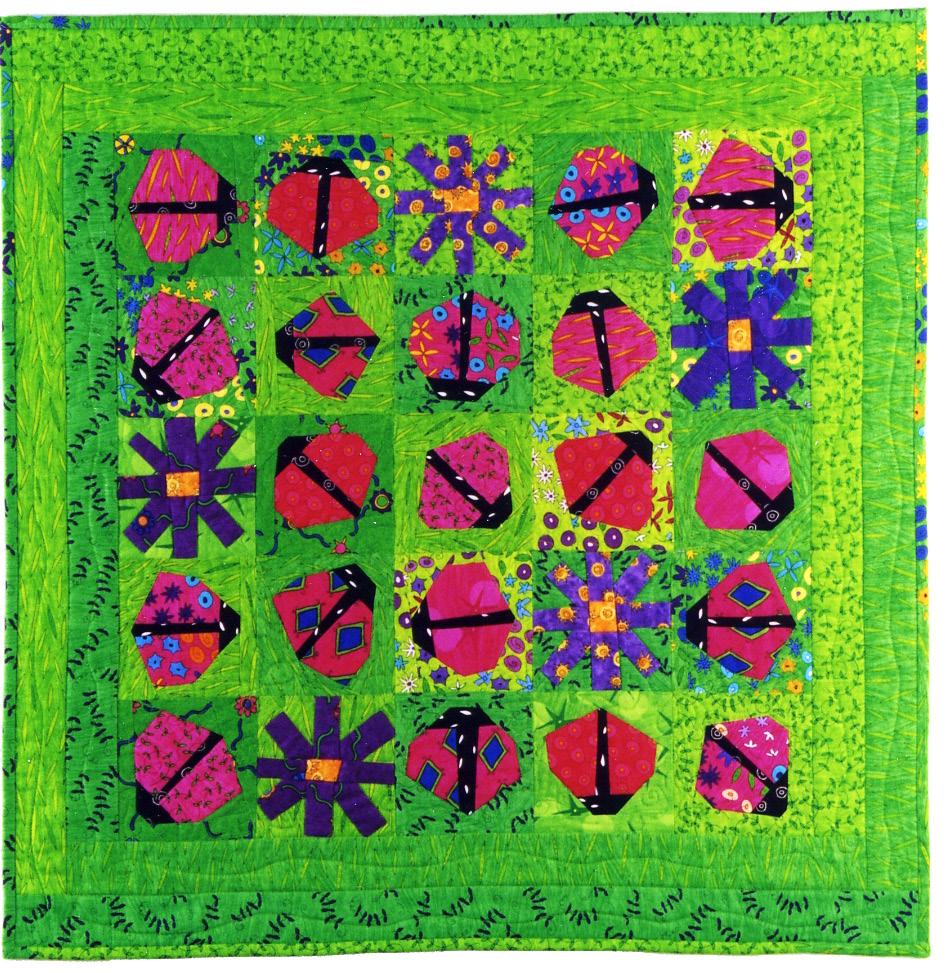 Colorful quilt with ladybug and flower patterns on a green background
