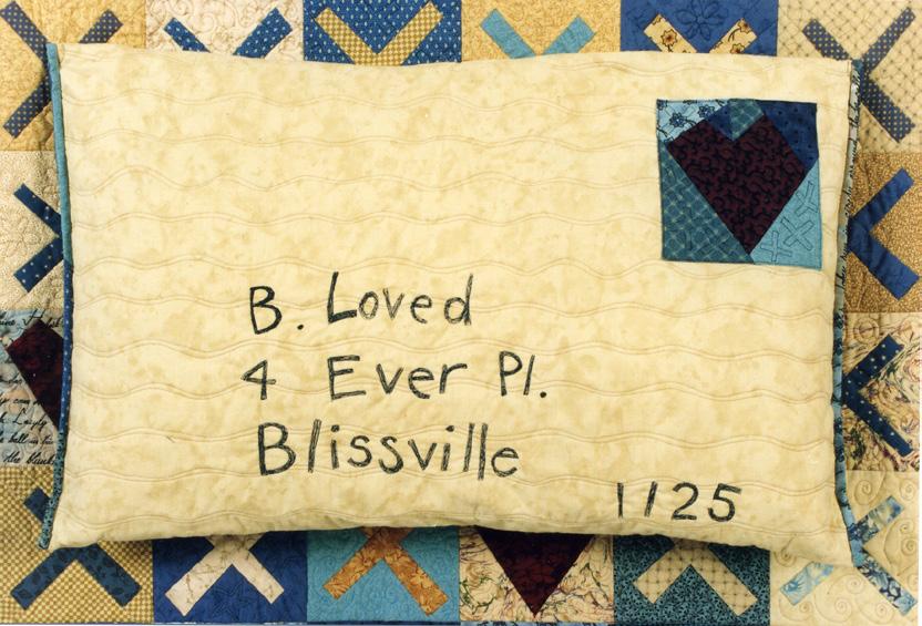Quilted pillow with love text on a quilt background