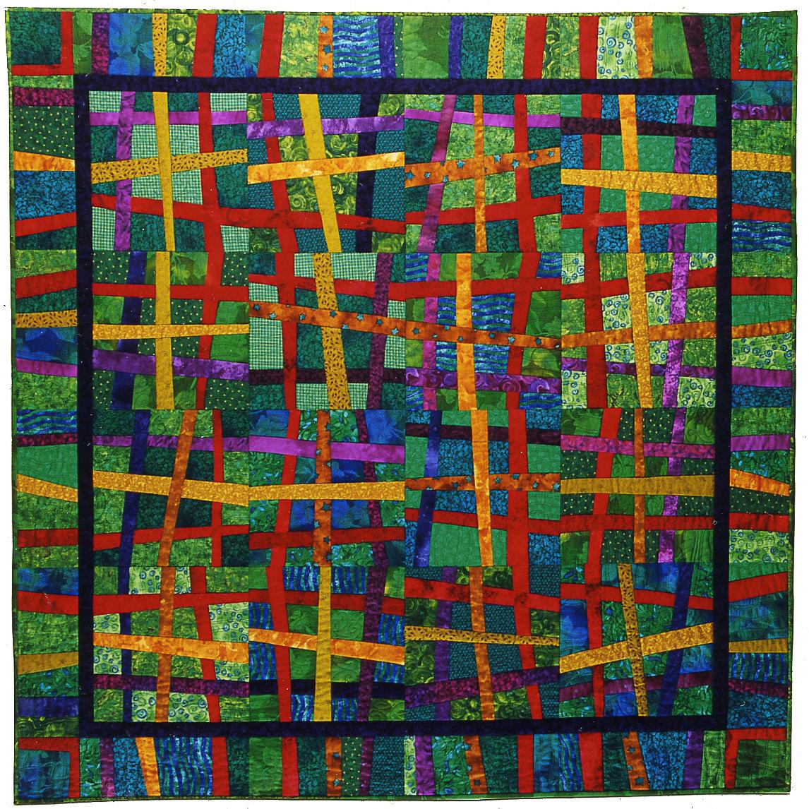 Colorful quilt with a geometric pattern featuring green, red, blue, and yellow.