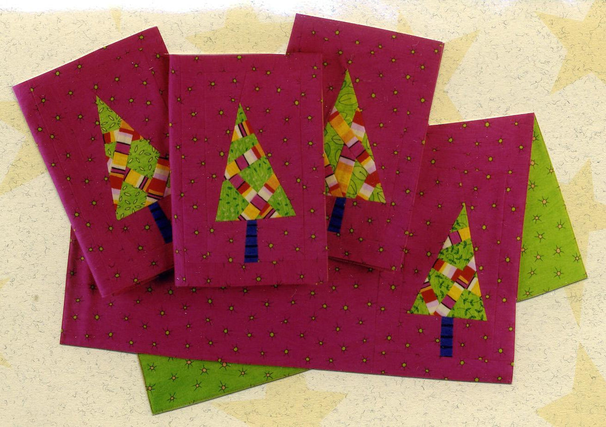 Four pink greeting cards with Christmas tree designs on a textured beige background